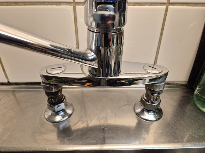 Kökskran med två ventiler under, möjligt att koppla diskmaskin. Kromad yta och vita kakelväggar i bakgrunden.