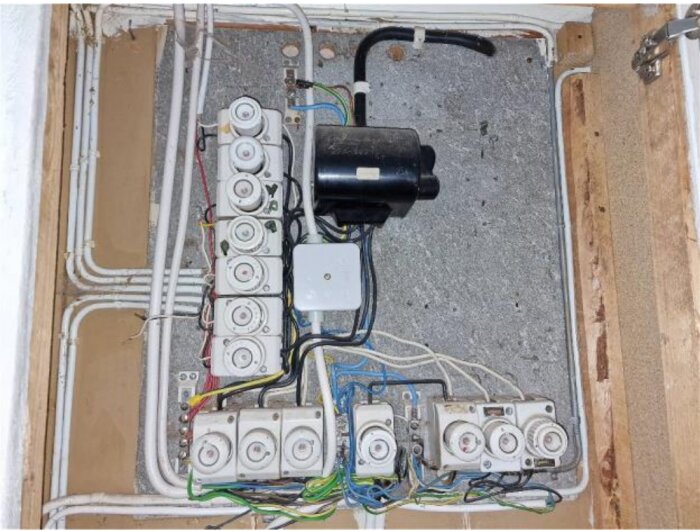 Elektrisk kopplingsbox med flera kablar och säkringar, del av en diskussion om skador.