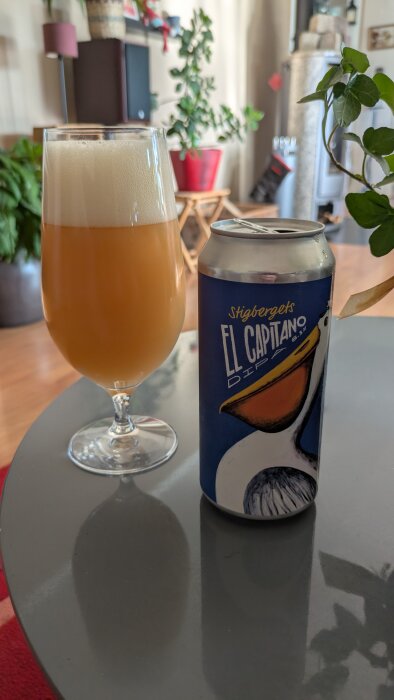 En Stigbergets El Capitano DIPA ölburk på ett bord bredvid ett glas med skummande öl.