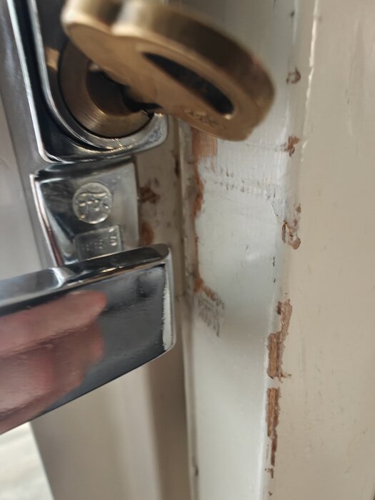 Dörrlås och karm med märken och en spricka.