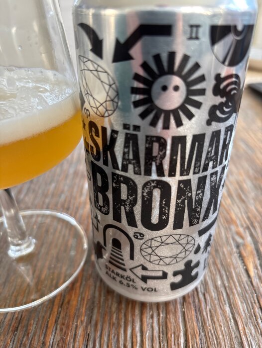 Burk med Skärmarbronx Ipa från Södra Maltfabriken, 6,5% vol, bredvid ett glas öl på träbord.