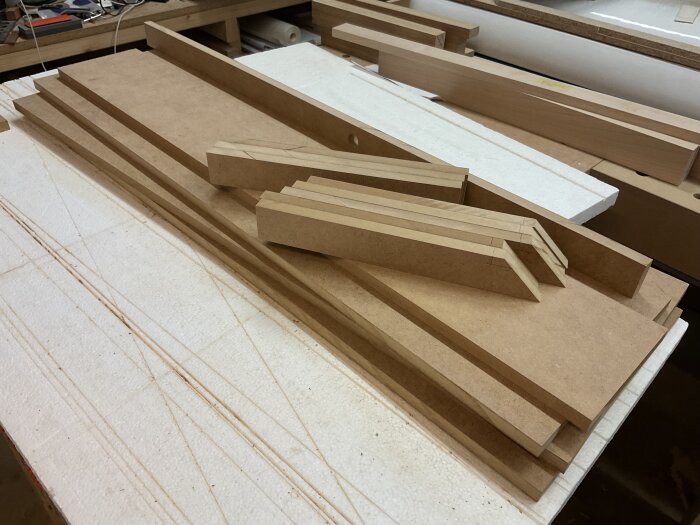 Skivor och lister av MDF ligger på en arbetsbänk, redo för att byggas ihop till ett högt anhåll för en justersåg.