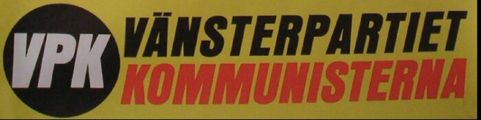 Gul skylt med texten "VPK Vänsterpartiet Kommunisterna" i svart och rött.