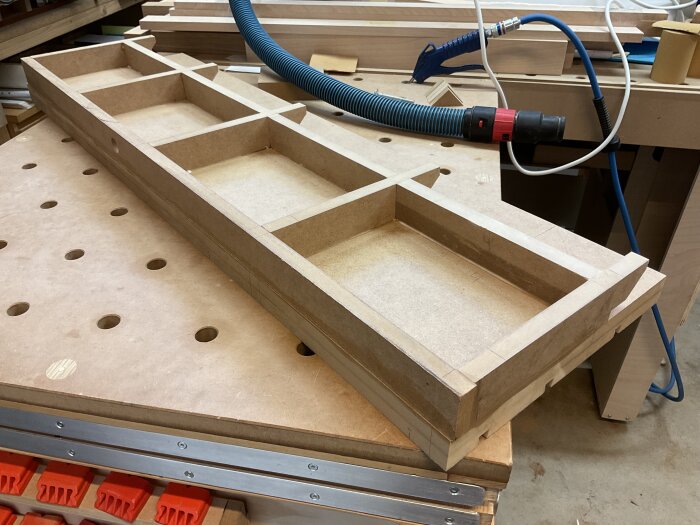 Högt anhåll av MDF med torsionsbox-design på en arbetsbänk i en verkstad, byggt för en justersåg.
