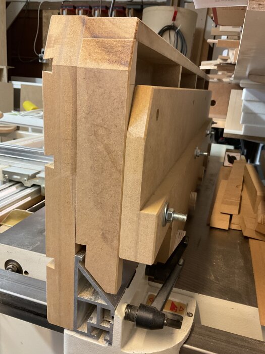 Högt anhåll till justersåg byggt av MDF med monterade vagnsbultar och fästen, del av pågående verkstadsprojekt för förbättrad precision och funktionalitet.