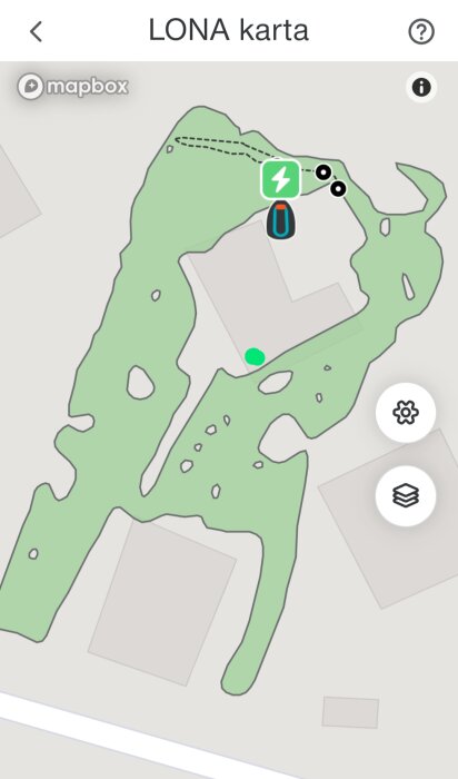 Karta över en gräsklipparens klippområde på en app, med markerad guidekabel som streckad linje och laddstationens läge med en ikon.