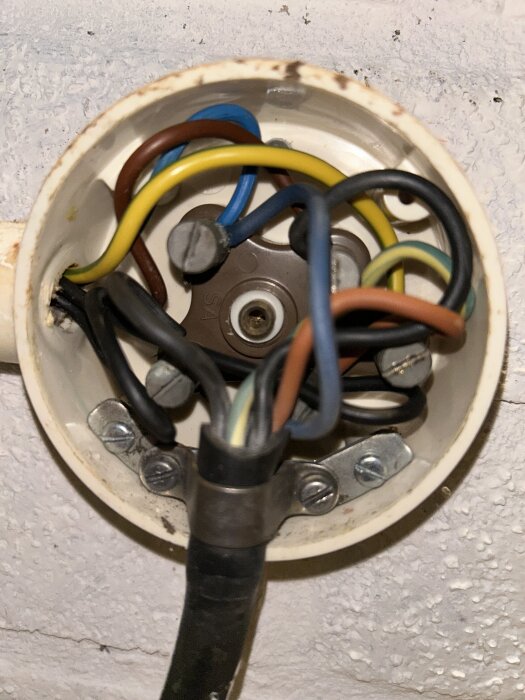 Anslutningsdosan med flera färgglada elledningar, monterad i tak.