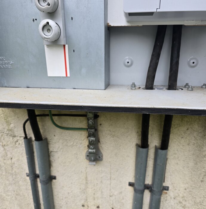 Elcentral med kablar och ett jordtag monterat på en vägg, del av ett reservkraftsystem för byggprojekt.