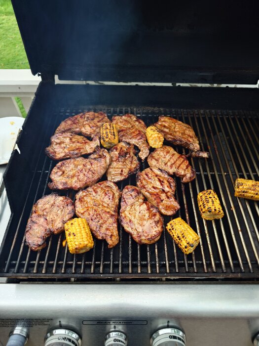 Grillad karré och majskolvar på en grill.