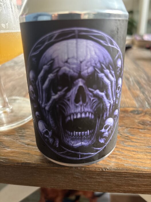 Ölburk med mörkt motiv föreställande en skalle omringad av skelett. Märket är Krypta Brewing Haze of Torment.