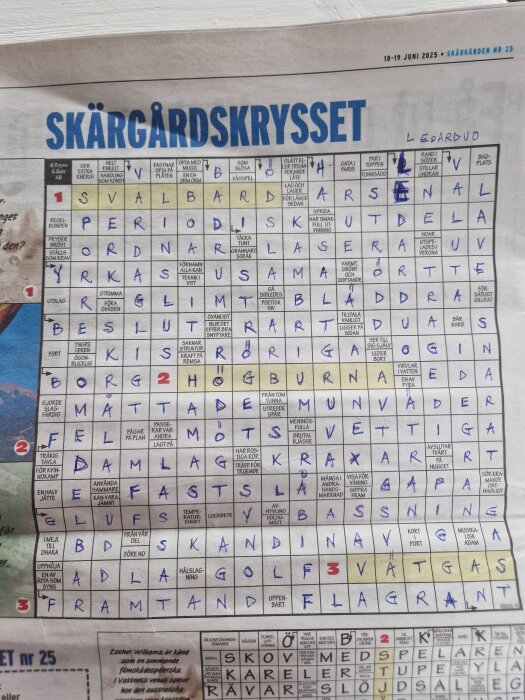 Tidning med korsord kallat "Skärgårdskrysset", delvis ifyllt med blå bläckpenna. Daterat 18-19 juni 2025, med olika frågor och svar.