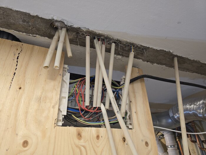 Bild av VP-rör och elkablar i en vägg under renovering, med synliga träpaneler och ledningar runtom.