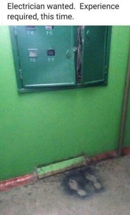 Ett öppet elskåp med exponerade kablar och brända fotavtryck på golvet nedanför. Texten ovan lyder: "Electrician wanted. Experience required, this time.