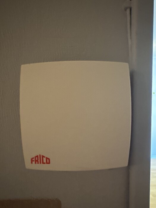 Värmeregleringspanel från Frico monterad på en vägg, saknar centralstyrning.