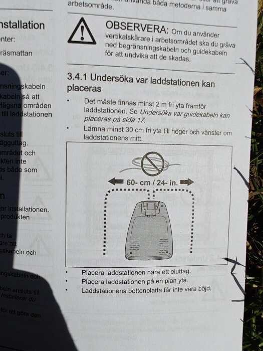 Instruktionsmanual för laddstation med rekommenderade avstånd för placering, visande minsta fria yta på 60 cm runt stationen.