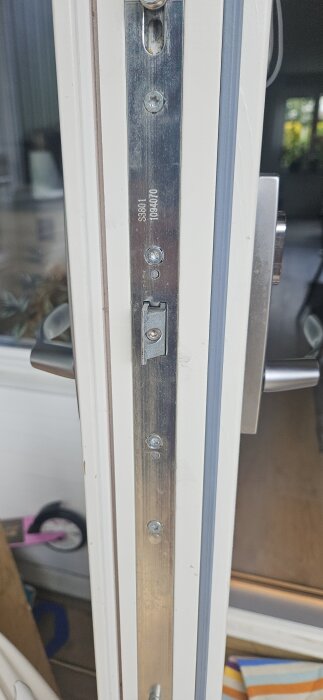 Närbild på en dörrkarm som visar en insida av en altandörr med låskistan Assa sf2010 monterad i en spanjolett.