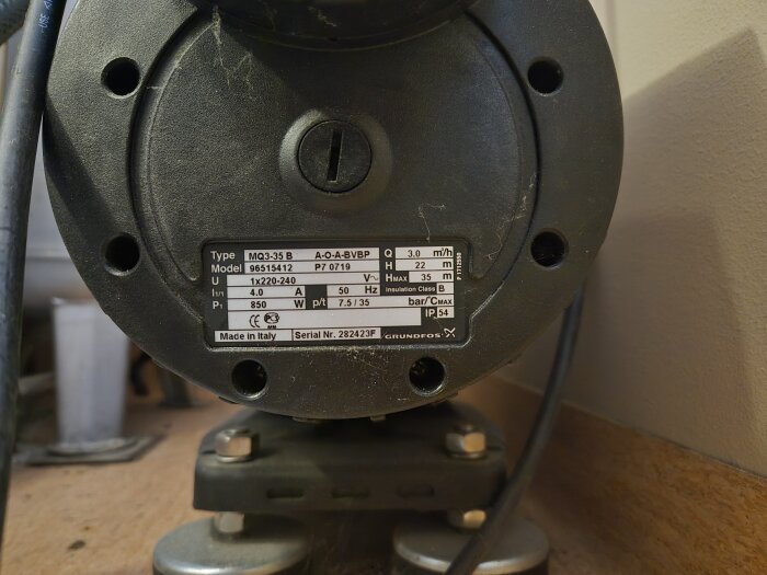 Vattenpump av märket Grundfos med modellnummer MQ3-35 B visas, med specifikationer och serienummer på etiketten.