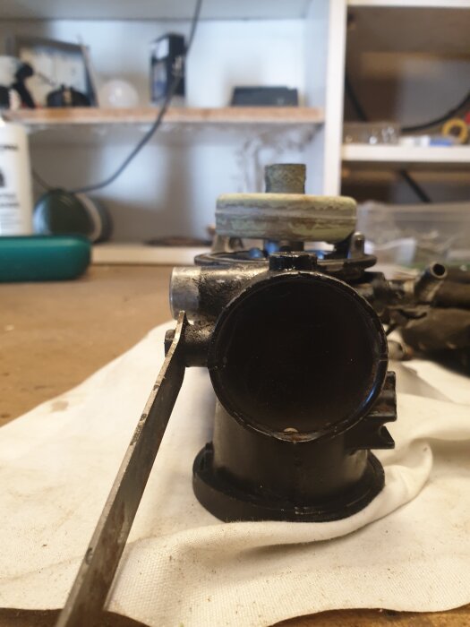 Förgasare till en 10 hk Briggs-motor, visande flottören ovanpå. Motorproblem nämns i texten.