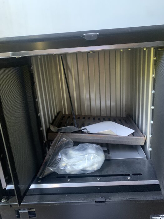 Öppen combitherm-kamin från 1980-talet med tillbehör inuti, funnen vid rensning av kattvind i ett torp.