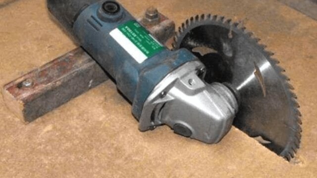 Elektrisk vinkelslip med sågklinga monterad på ett bord.