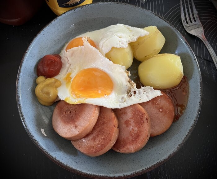 Stekt falukorv med hög kötthalt, fÀrskpotatis, stekt Àgg sunny side up, ketchup och senap pÄ en tallrik.