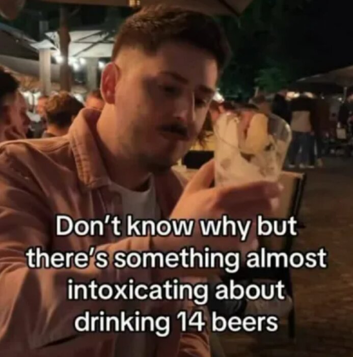 En man håller i ett ölglas och ler med texten "Don’t know why but there’s something almost intoxicating about drinking 14 beers" över bilden.