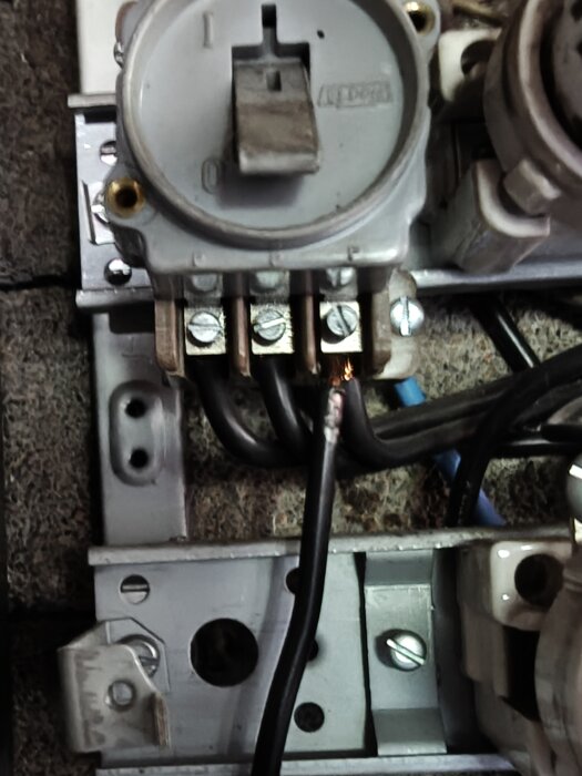 Sliten och potentiellt farlig diazed central med frilagd koppartråd och gnistbildning.