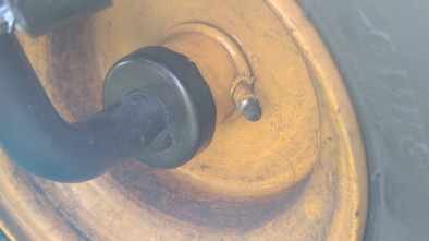 Trädgårdstraktorns hjul demonterat, visar löst lager och axel.