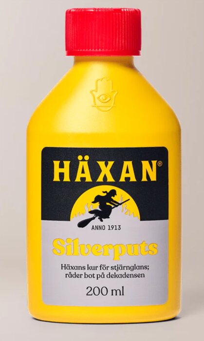 Flaska med Häxans silverputs, gul förpackning med röd kork och etikett med en häxa på kvast. Används för att putsa silver.
