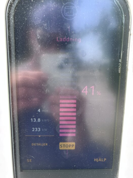Skärm på en laddstolpe visar laddningsstatus. Laddning pågår med 41% batteri, 233 kW effekt, 13.8 kWh energi påfylld; laddningstid 4 minuter.
