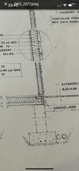 Byggnadsritning som visar detalj av en huskonstruktion med bjälkar, altangolv och hängseljärn. Isolering mellan bjälkar framhävd.