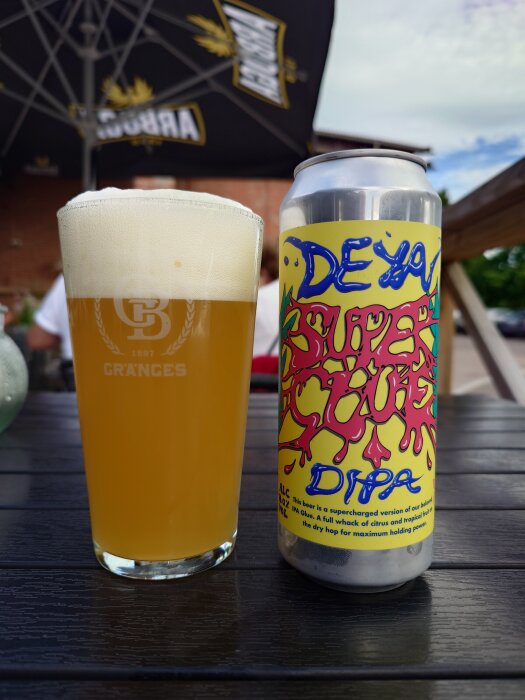 Burk Deya Super Glue DIPA och ett glas öl utomhus på Broken Dreams under ett parasoll.