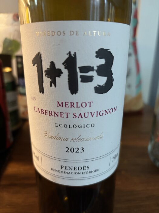 En vinflaska med etiketten "1+1=3", Merlot Cabernet Sauvignon, ekologiskt, årgång 2023, från Penedès.