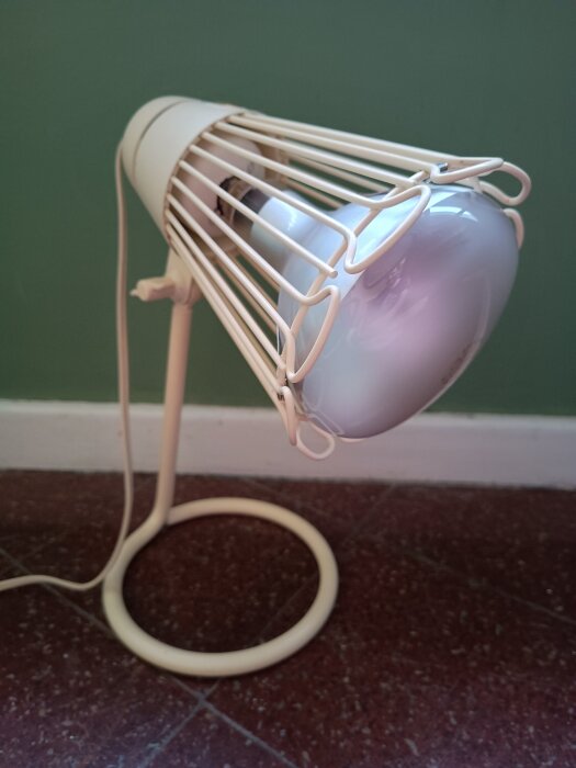 Kvartslampa på metallställ, används för att avdöda mögel på vitkalkad källarvägg, avger ozondoft.
