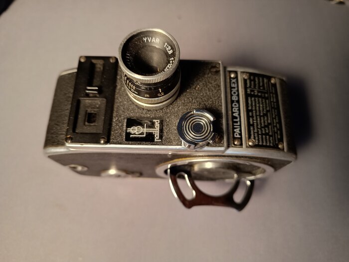 En vintage Paillard Bolex-kamera från 1950-talet, visas ovanifrån med objektiv och sidopanel med text.