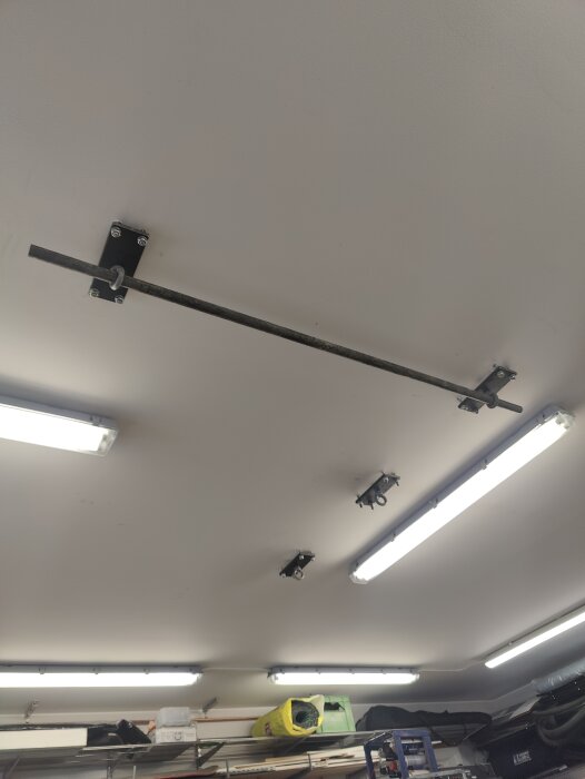 Ögglor monterade i garagets tak med plåt och gängstång, redo för hiss och vinschinstallation.