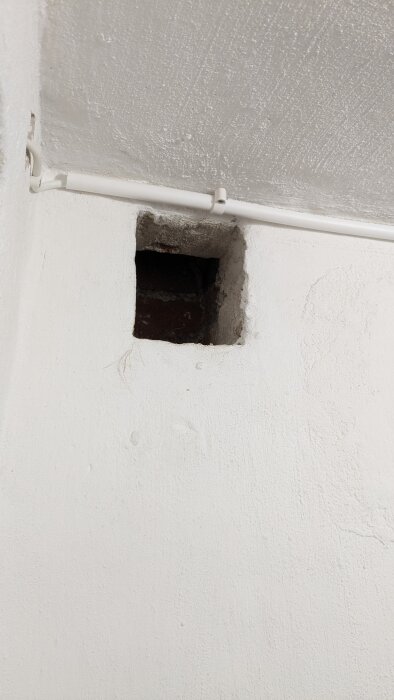 Ventilationskanal i källarvägg, fyrkantig öppning, del av murstock.