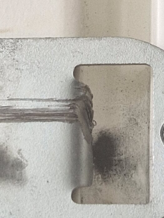 Skadad dörrkarm på altandörr med märken från dörrkolvar, visar justeringsproblem där dörren knappt går att låsa.