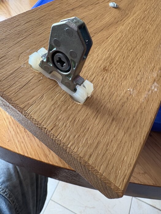 Metallbeslag monterat på en träskivas kant, frågaställning om det kan tas bort.