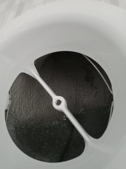 Vit ventilationskanal med öppning mot svart bakgrund.