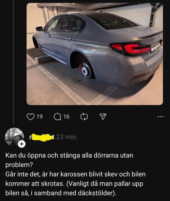 GrÄ bil i garage utan dÀck, uppallad pÄ trÀblock.