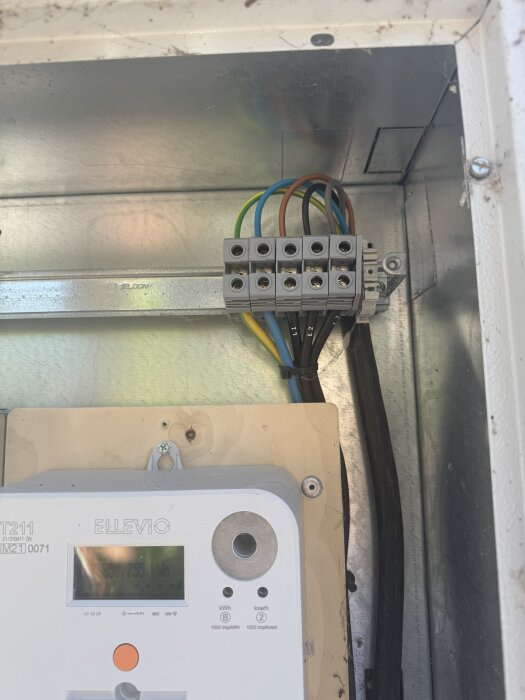 Elmätare och kopplingsbox med ledningar anslutna i nedre högra ingångarna på plinten.