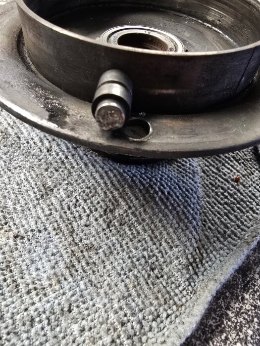 Metallkomponent på en matta, eventuellt en del av en svetsuppgift eller DIY-projekt.