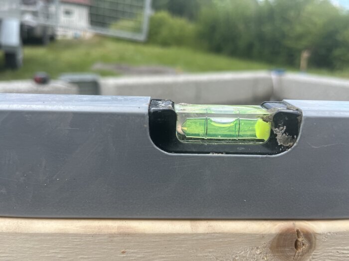 Vattenpass visar att ytan är i våg över träbalk.