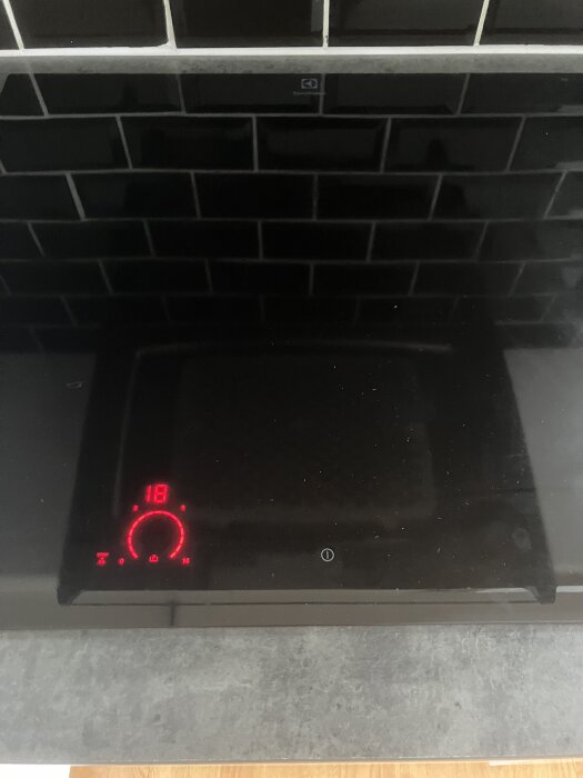 Elektrisk spishäll Electrolux med digital display som visar siffran 18; bekymmer med avstängning och felkoder uppges i forumtråd.