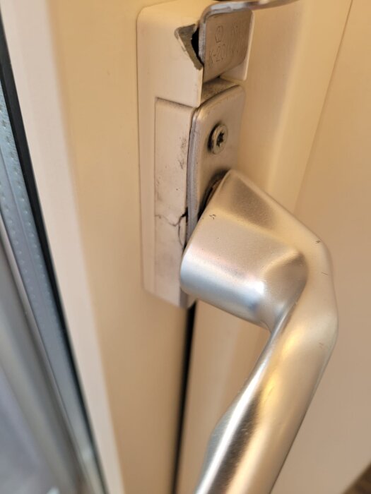 Trasigt plastföremål vid dörrhandtag på balkongdörr.