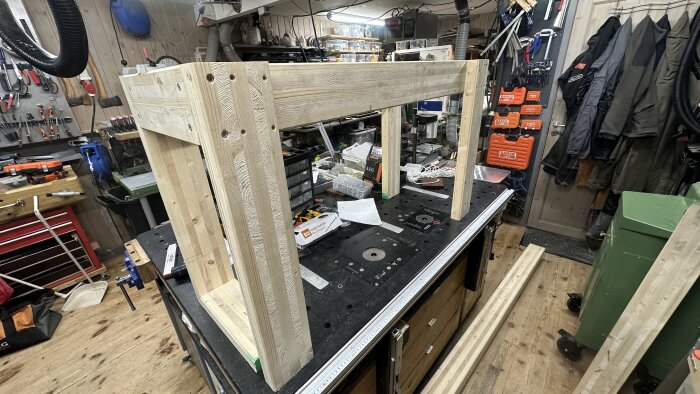 Träunderrede till mobil arbetsbänk under konstruktion i verkstad. Verktyg och utrustning synliga i bakgrunden.