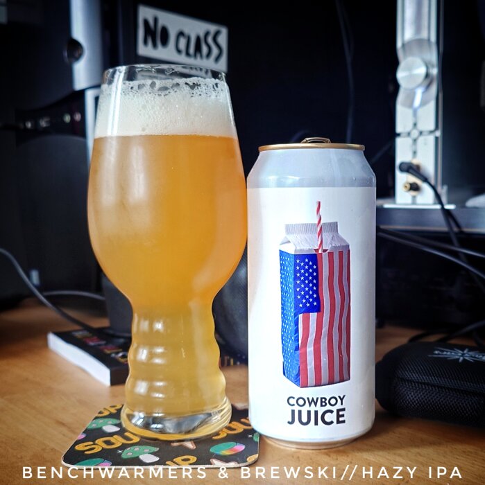 Ölglas med hazy IPA bredvid en ölburk märkt "Cowboy Juice" med amerikanskt flaggmotiv.