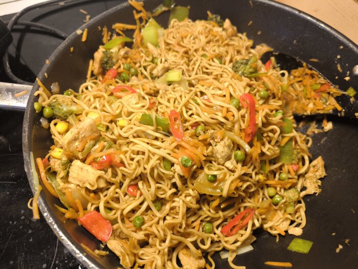 Wokpanna med nudlar, paprika, chili, purjolök, lök, morötter, kyckling och såser, perfekt för matlådor inför veckan.