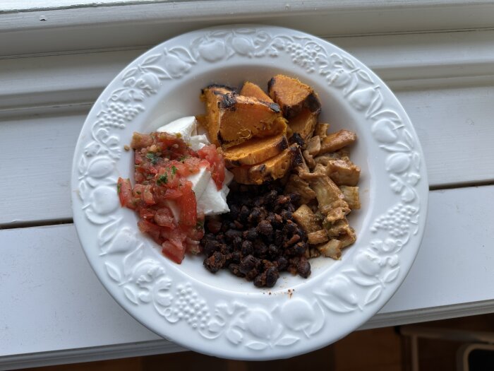 Tallrik med sötpotatis, pico de gallo, flundra, svarta bönor och mozzarella.